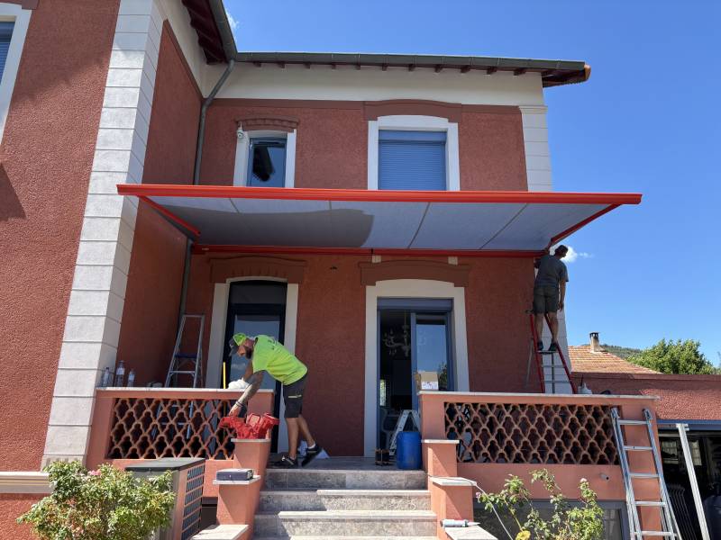 Installez un store banne coffre Designa rouge corail à Manosque avec MBC Menuiseries. Confort, élégance, motorisation Somfy et pose sur mesure certifiée RGE